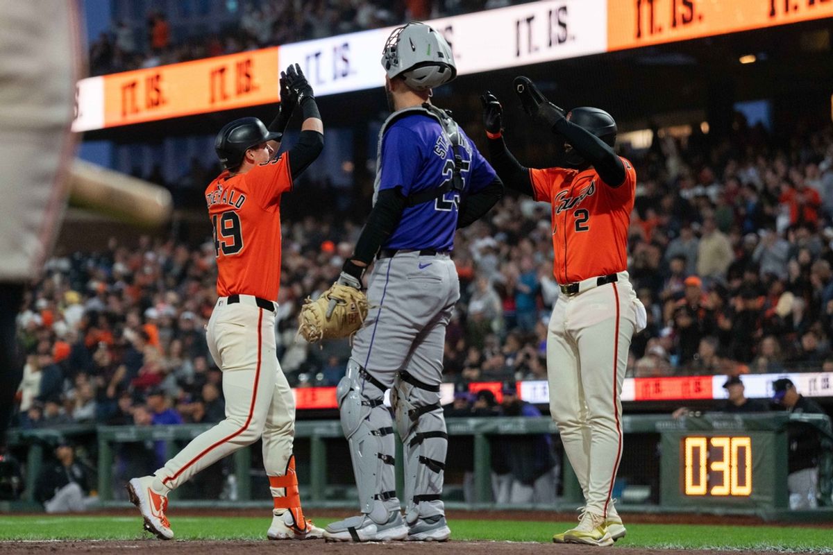 Jul 26, 2024; San Francisco, California, USA;  Colorado Rockies catcher Jacob Stallings (25) watches San Francisco Giants outfielder Tyler Fitzgerald (49) and designated hitter Jorge Soler (2) celebrate during the fourth inning at Oracle Park. Mandatory Credit: Stan Szeto-USA TODAY Sports