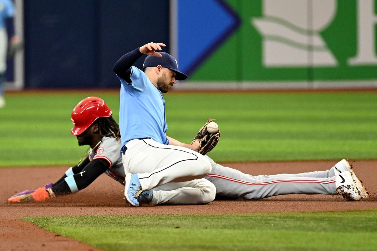 Jul 28, 2024; St. Petersburg, Florida, USA; Cincinnati Reds short stop Elly De La Cruz (44) slides into second base as Tampa Bay Rays second baseman Brandon Lowe (8) attempts to catch the ball in the first inning at Tropicana Field. Mandatory Credit: Jonathan Dyer-USA TODAY Sports