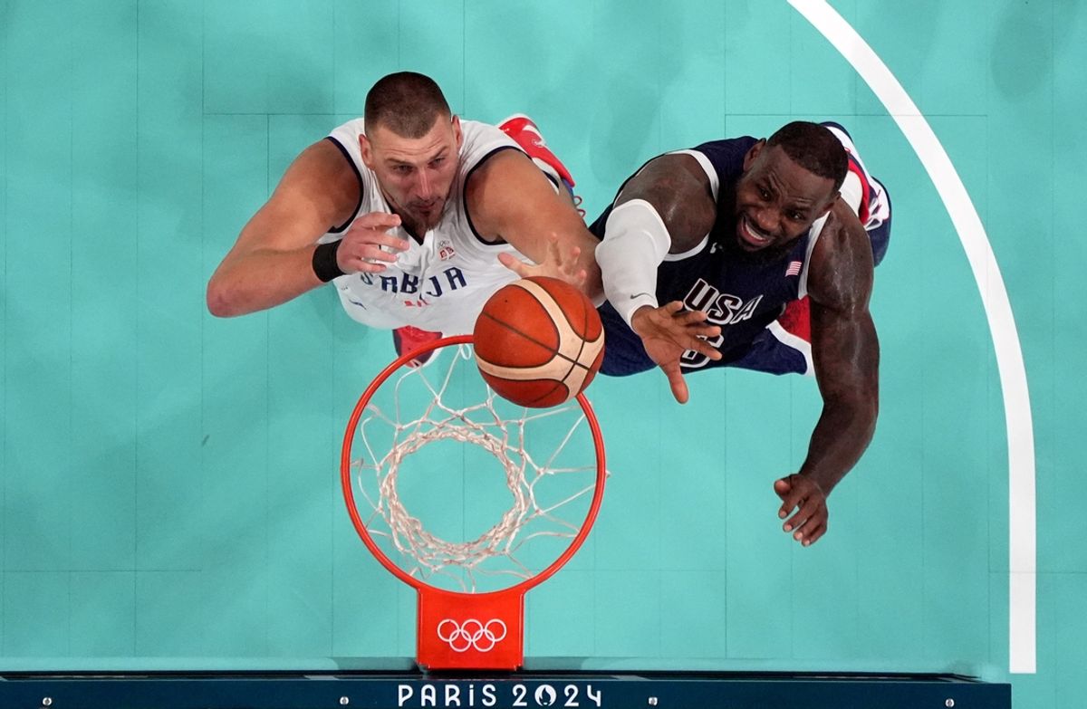 Jul 28, 2024; Villeneuve-d'Ascq, France; Serbia power forward Nikola Jokic (15) and United States guard Lebron James (6) jump for a rebound in the fourth quarter during the Paris 2024 Olympic Summer Games at Stade Pierre-Mauroy. Mandatory Credit: John David Mercer-USA TODAY Sports