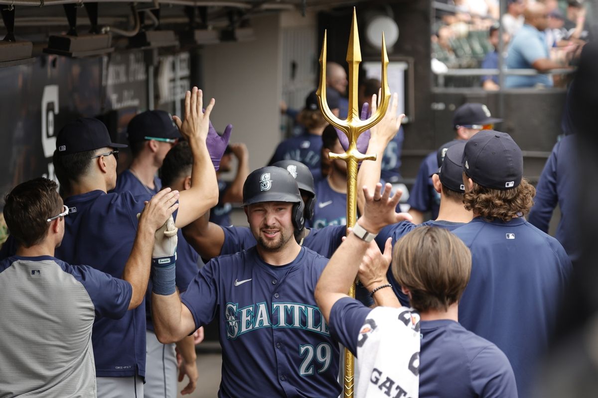 Jul 28, 2024; Chicago, Illinois, USA; Seattle Mariners catcher Cal Raleigh (29) celebrates with teammates in the dugout after hitting a two-run home run against the Chicago White Sox during the first inning at Guaranteed Rate Field. Mandatory Credit: Kamil Krzaczynski-USA TODAY Sports