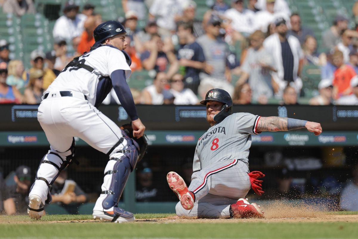 Jul 28, 2024; Detroit, Michigan, USA;  Minnesota Twins catcher Christian Vazquez (8) slides in safe at home in the ninth inning against the Detroit Tigers at Comerica Park. Mandatory Credit: Rick Osentoski-USA TODAY Sports