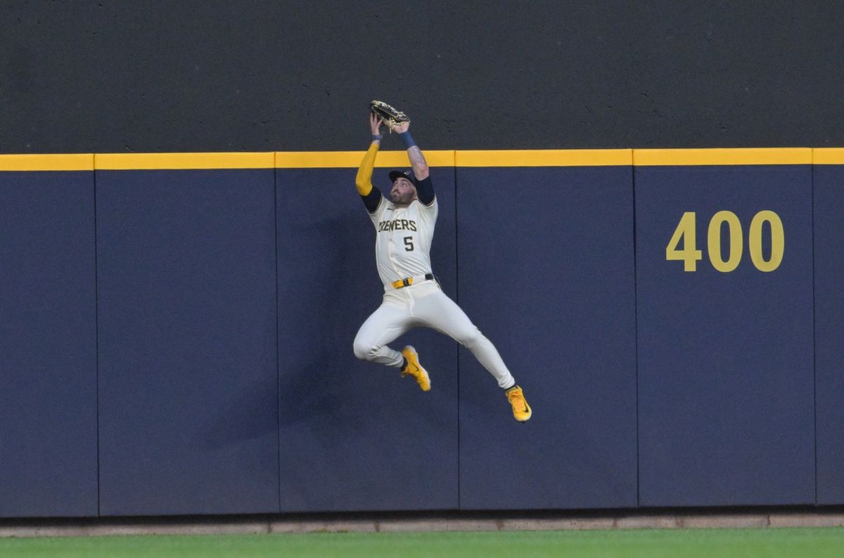 Jul 29, 2024; Milwaukee, Wisconsin, USA; Milwaukee Brewers outfielder Garrett Mitchell (5) robs a home run from the Atlanta Braves in the fourth inning at American Family Field. Mandatory Credit: Michael McLoone-USA TODAY Sports