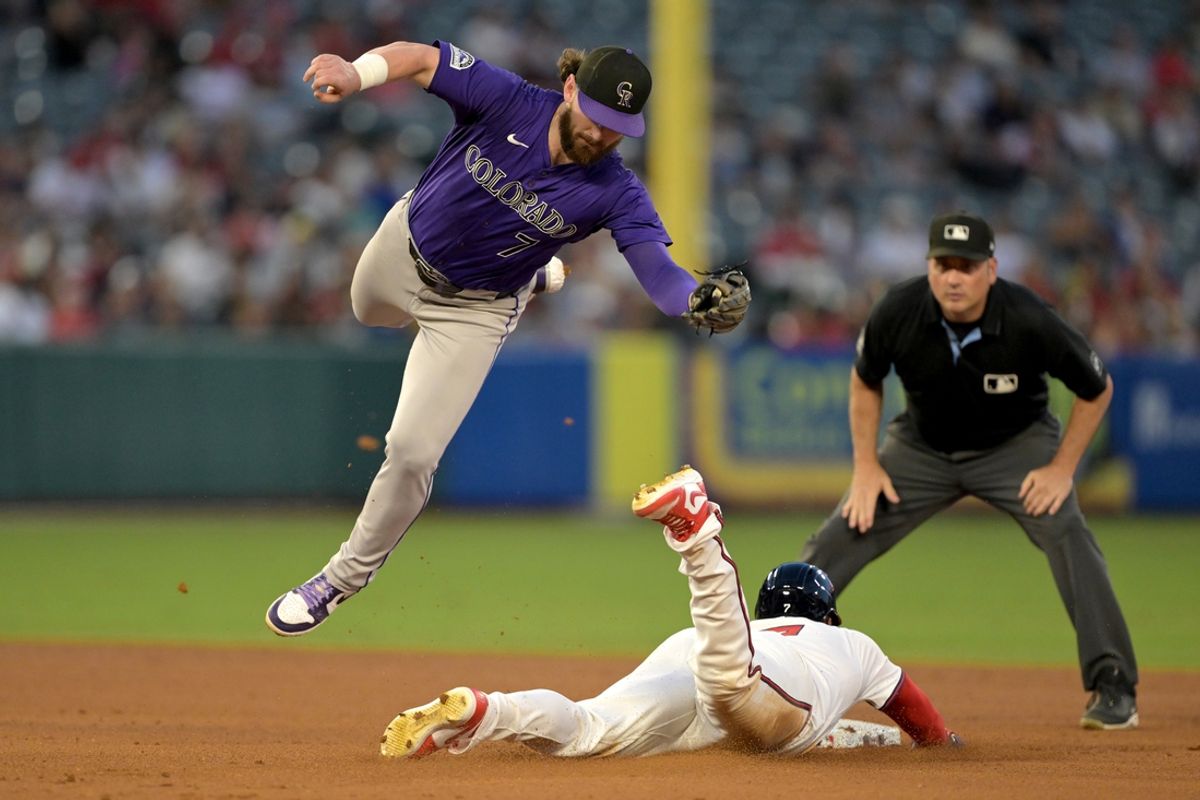 Aug 1, 2024; Anaheim, California, USA;  Los Angeles Angels right fielder Jo Adell (7) dives under the tag by Colorado Rockies second baseman Brendan Rodgers (7) for a stolen base in the fifth inning at Angel Stadium. Mandatory Credit: Jayne Kamin-Oncea-USA TODAY Sports