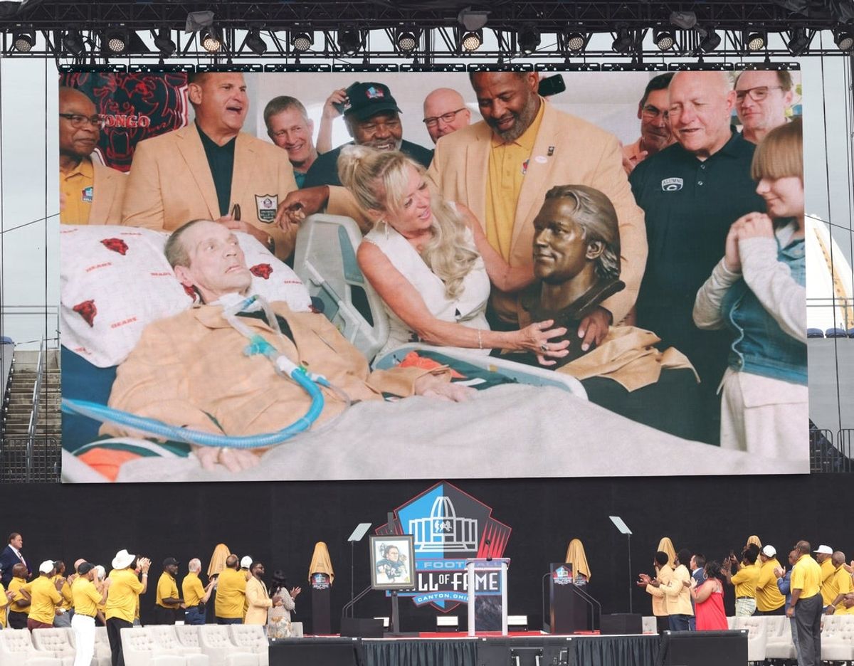 Chicago Bear Steve McMichael and his wife, Misty, unveil his bust at their Chicago home with former teammates during a video unveiling at the Pro Football Hall of Fame on Saturday, Aug. 3, 2024, in Canton, Ohio, at Tom Benson Hall of Fame Stadium.