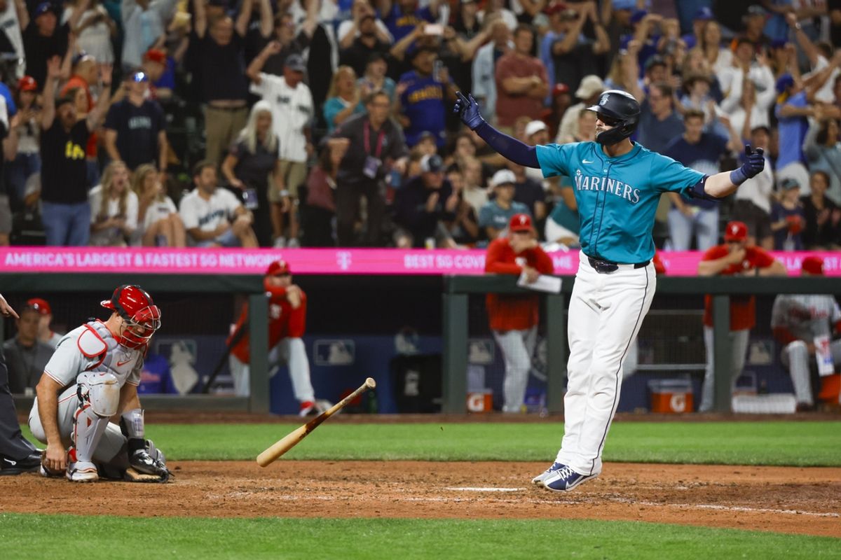 Aug 3, 2024; Seattle, Washington, USA; Seattle Mariners right fielder Mitch Haniger (17, right) celebrates after drawing a walk-off walk during the tenth inning against the Philadelphia Phillies at T-Mobile Park. Philadelphia Phillies catcher J.T. Realmuto (10) reacts at left. Mandatory Credit: Joe Nicholson-USA TODAY Sports