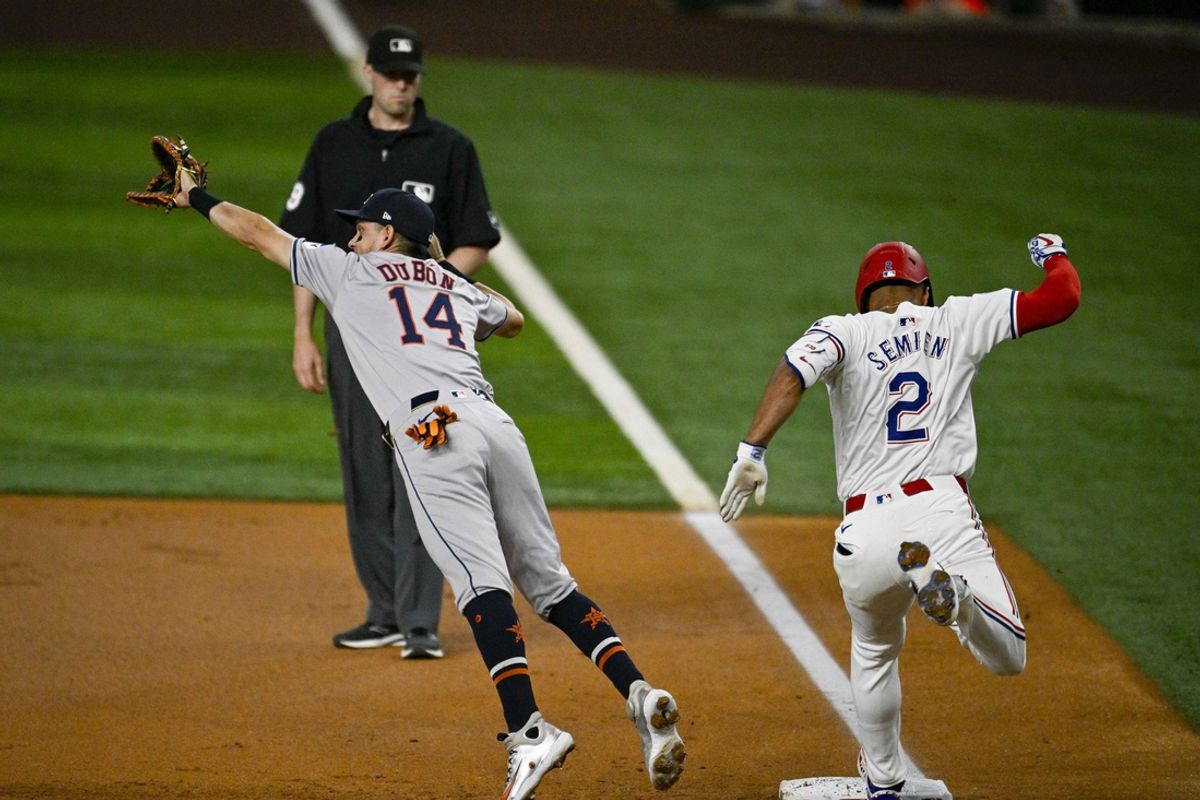 Aug 5, 2024; Arlington, Texas, USA; Texas Rangers second baseman Marcus Semien (2) beats out the throw to Houston Astros first baseman Mauricio Dubon (14) during the first inning at Globe Life Field. Mandatory Credit: Jerome Miron-USA TODAY Sports