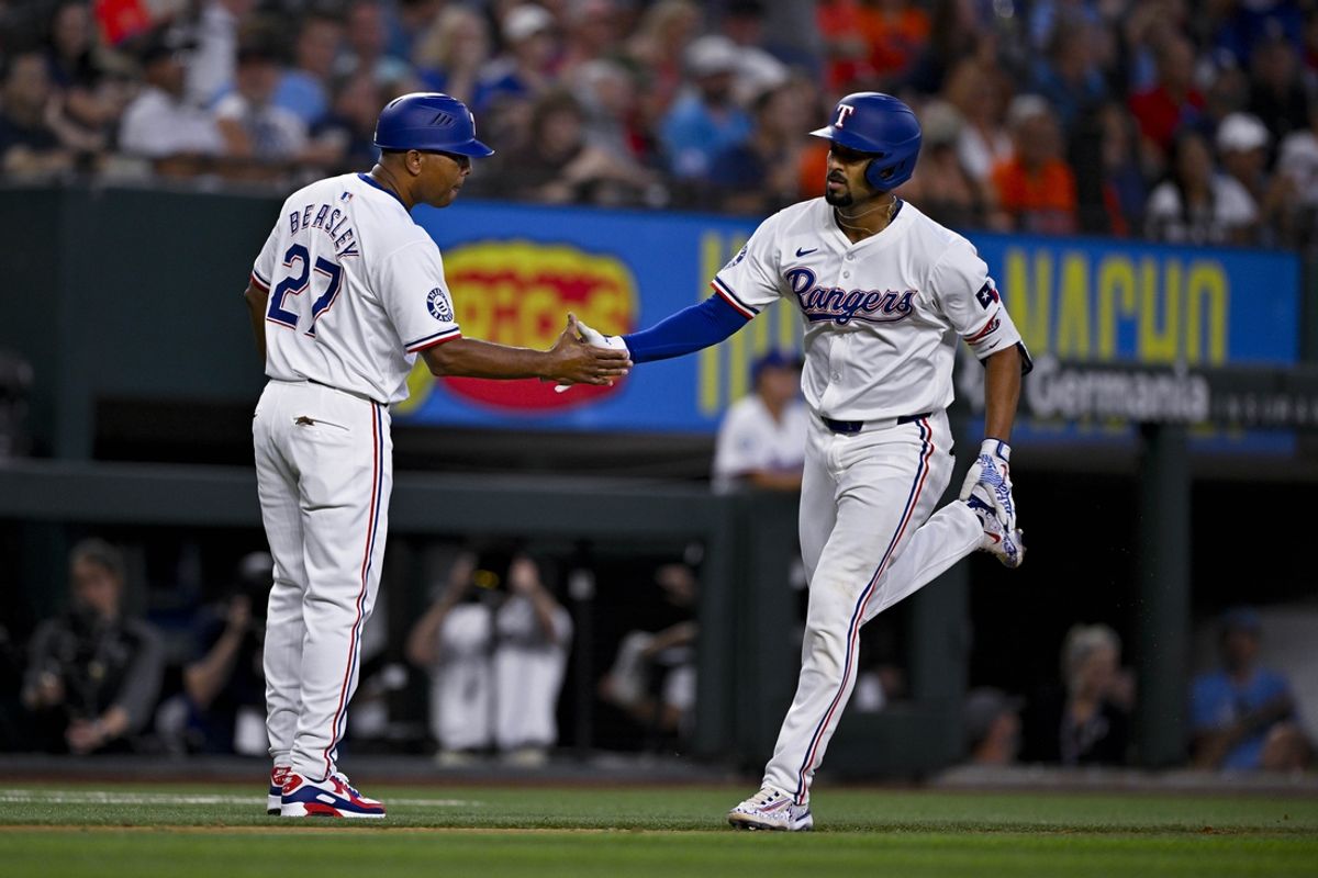 Aug 7, 2024; Arlington, Texas, USA;  Texas Rangers second baseman Marcus Semien (2) rounds the bases past third base coach Tony Beasley (27) after Semien hits a home run against the Houston Astros during the sixth inning at Globe Life Field. Mandatory Credit: Jerome Miron-USA TODAY Sports
