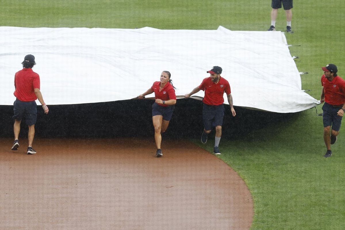 Aug 7, 2024; Washington, District of Columbia, USA; The Washington Nationals grounds crew drags the infield tarp during a rain delay against the San Francisco Giants during the eighth inning at Nationals Park. Mandatory Credit: Geoff Burke-Imagn Images