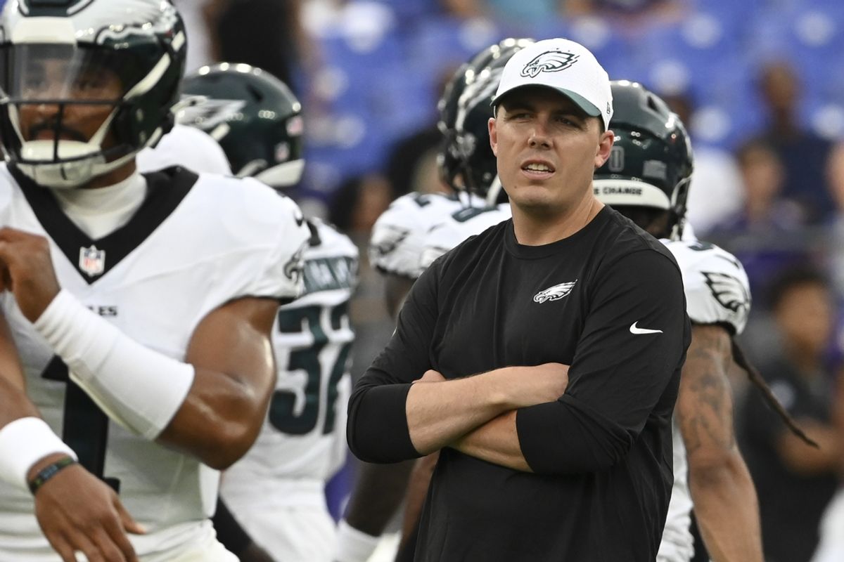 Aug 9, 2024; Baltimore, Maryland, USA;  Philadelphia Eagles offensive coordinator Kellen Moore looks on as quarterback Jalen Hurts (1) throws before a preseason game against the Baltimore Ravens at M&T Bank Stadium. Mandatory Credit: Tommy Gilligan-Imagn Images