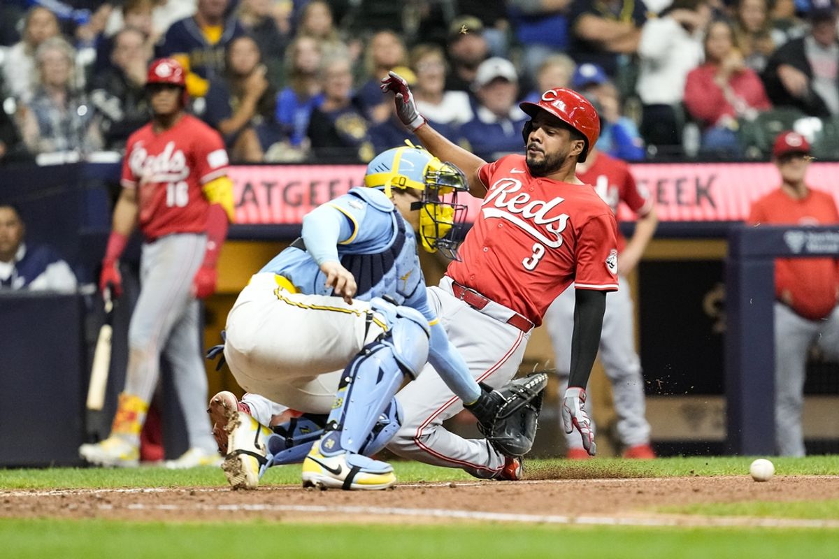 Aug 9, 2024; Milwaukee, Wisconsin, USA;  Cincinnati Reds designated hitter Jeimer Candelario (3) slides into home as Milwaukee Brewers catcher William Contreras (24) fields the throw during the seventh inning at American Family Field. Mandatory Credit: Jeff Hanisch-USA TODAY Sports