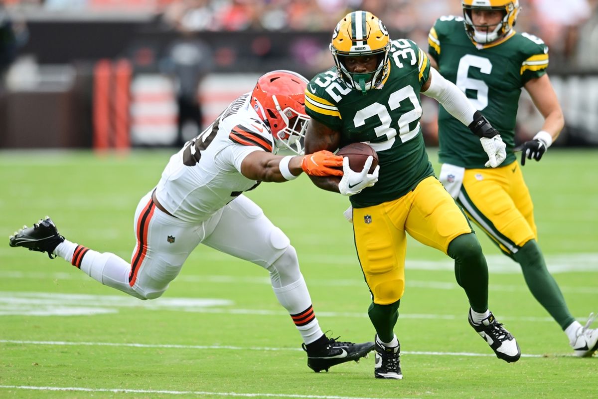 Aug 10, 2024; Cleveland, Ohio, USA; Green Bay Packers running back MarShawn Lloyd (32) runs with the ball as Cleveland Browns linebacker Caleb Johnson (48) defends during the second half at Cleveland Browns Stadium. Mandatory Credit: Ken Blaze-Imagn Images