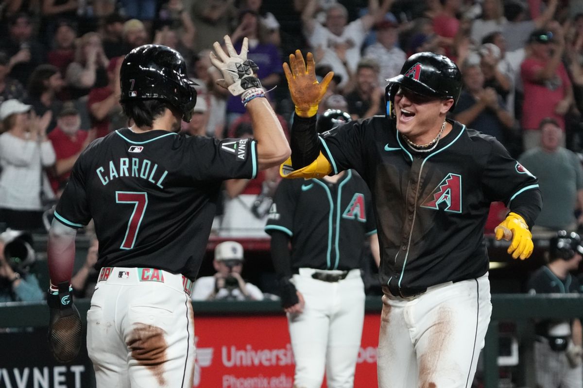 Aug 14, 2024; Phoenix, Arizona, USA; Arizona Diamondbacks designated hitter Joc Pederson (right) celebrates with outfielder Corbin Carroll (7) after scoring a run on a throwing error against the Colorado Rockies in the first inning at Chase Field. Mandatory Credit: Rick Scuteri-USA TODAY Sports