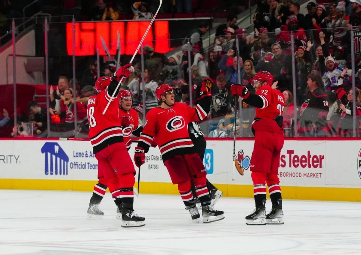 Jan 13, 2024; Raleigh, North Carolina, USA;  Carolina Hurricanes defenseman Brett Pesce (22) celebrates his game winning overtime goal with center Seth Jarvis (24) left wing Teuvo Teravainen (86) and left wing Brendan Lemieux (28) against the Pittsburgh Penguins at PNC Arena.