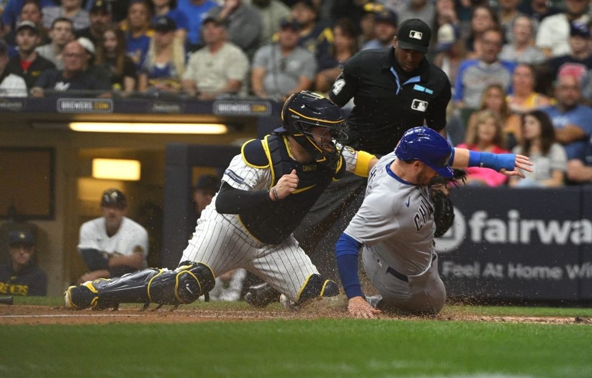 Sep 30, 2023; Milwaukee, Wisconsin, USA; Chicago Cubs left fielder Ian Happ (8) is tagged out by Milwaukee Brewers catcher Victor Caratini (7) in the fourth inning at American Family Field.