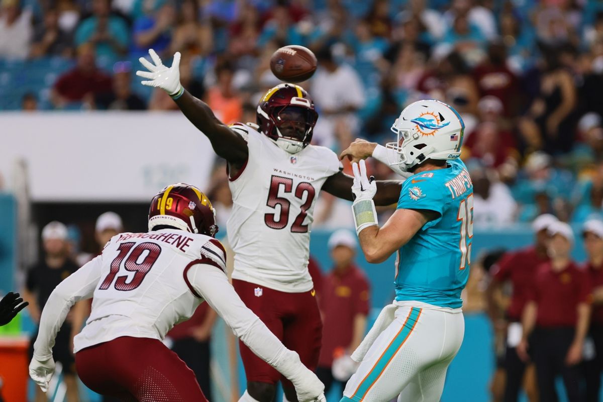 Aug 17, 2024; Miami Gardens, Florida, USA; Miami Dolphins quarterback Skylar Thompson (19) throws the football as Washington Commanders linebacker Jamin Davis (52) defends during the second quarter of a preseason game at Hard Rock Stadium. Mandatory Credit: Sam Navarro-Imagn Images