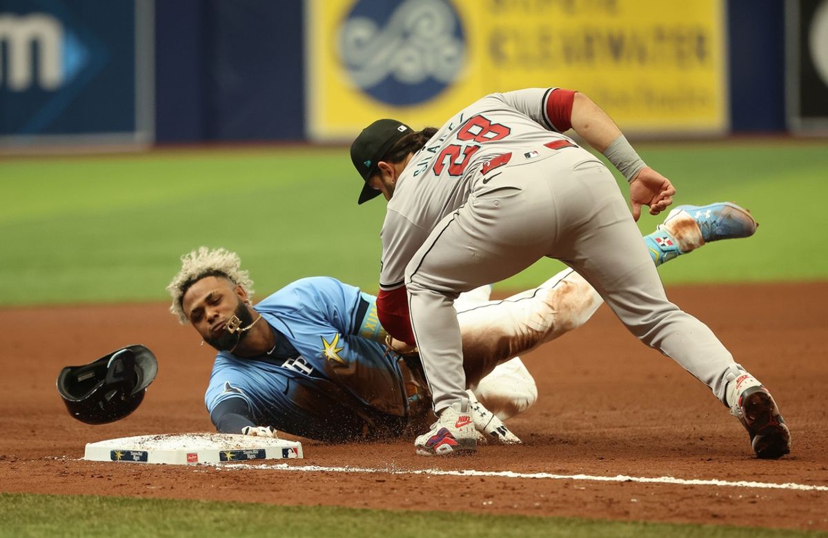 Aug 18, 2024; St. Petersburg, Florida, USA; Tampa Bay Rays third baseman Junior Caminero (13) slides safe into third base as Arizona Diamondbacks third base Eugenio Suarez (28) attempted to tag him out during the fifth inning at Tropicana Field. Mandatory Credit: Kim Klement Neitzel-USA TODAY Sports