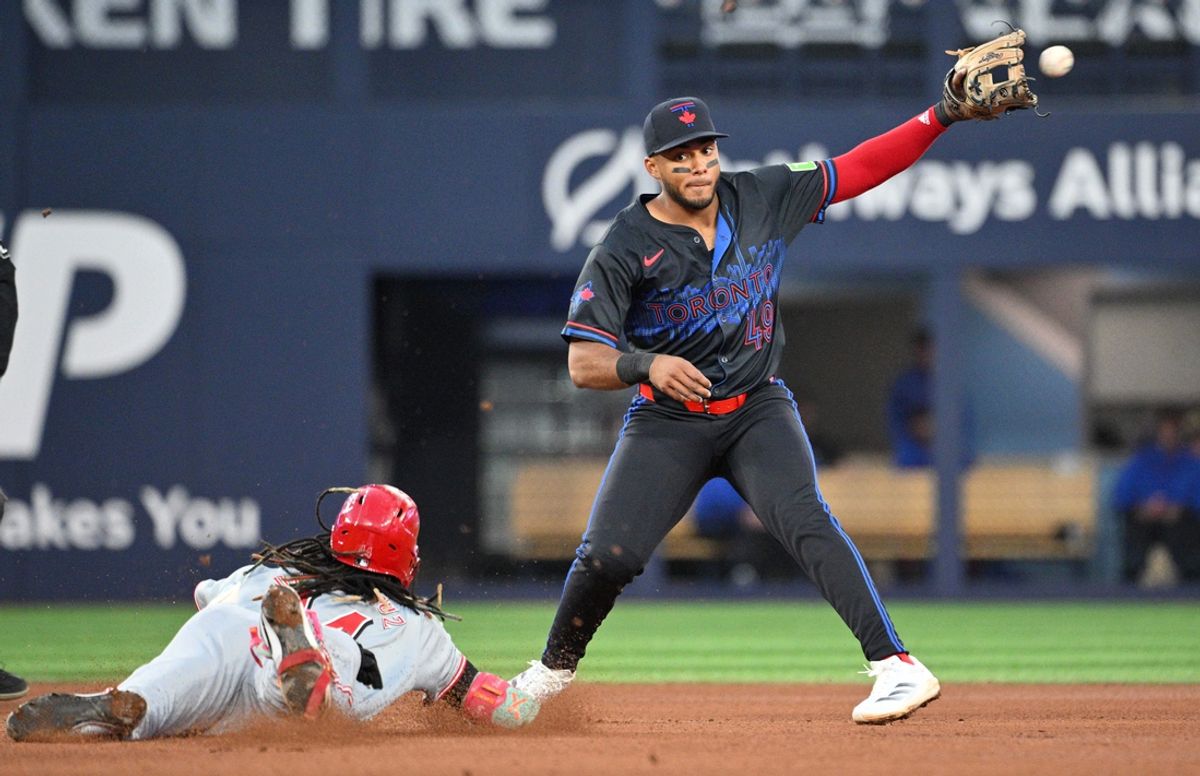 Aug 21, 2024; Toronto, Ontario, CAN;  Toronto Blue Jays second baseman Leo Jimenez (49) takes a throw from the outfield before tagging out Cincinnati Reds shortstop Elly De La Cruz (44) who tried to stretch a single into a double in the fourth inning at Rogers Centre. Mandatory Credit: Dan Hamilton-USA TODAY Sports