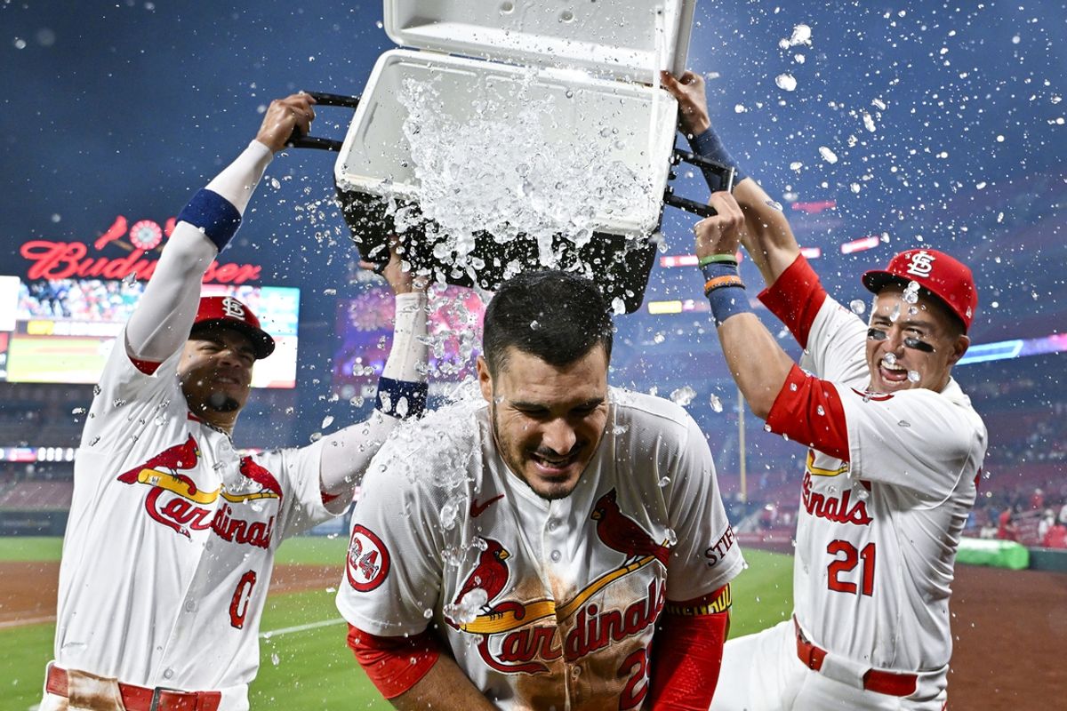 Aug 21, 2024; St. Louis, Missouri, USA;  St. Louis Cardinals third baseman Nolan Arenado (28) is doused with water by shortstop Masyn Winn (0) and center fielder Lars Nootbaar (21) after hitting a walk-off grand slam against the Milwaukee Brewers during the tenth inning at Busch Stadium. Mandatory Credit: Jeff Curry-USA TODAY Sports