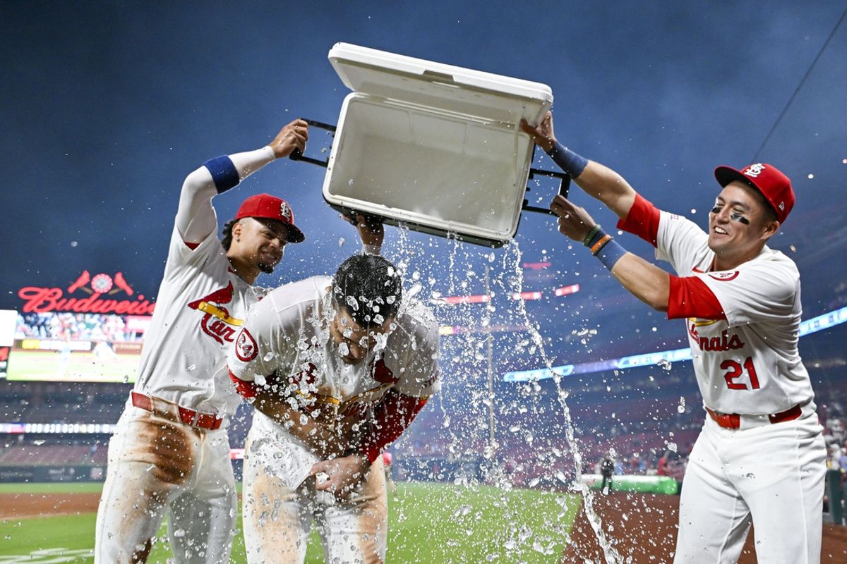 Aug 21, 2024; St. Louis, Missouri, USA;  St. Louis Cardinals third baseman Nolan Arenado (28) is doused with water by shortstop Masyn Winn (0) and center fielder Lars Nootbaar (21) after hitting a walk-off grand slam against the Milwaukee Brewers during the tenth inning at Busch Stadium. Mandatory Credit: Jeff Curry-USA TODAY Sports
