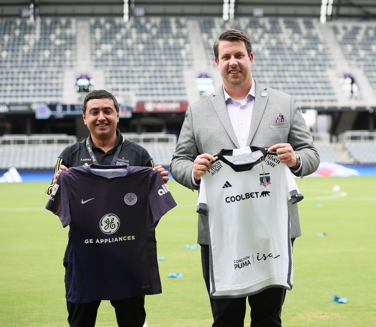 Aug 13, 2024; Louisville, KY, USA;  Colo-Colo representative and Racing Louisville FC general manager Ryan Dell (right) exchange jerseys before the Women's Cup game at Lynn Family Stadium. Mandatory Credit: EM Dash-Imagn Images