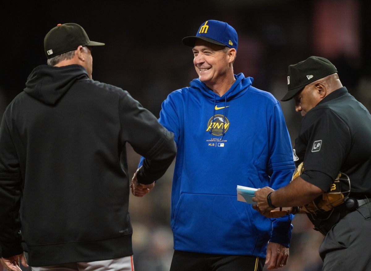 Aug 23, 2024; Seattle, Washington, USA; Seattle Mariners manager Dan Wilson, center, greets San Francisco Giants pitching coach Pete Woodworth before a game at T-Mobile Park. Mandatory Credit: Stephen Brashear-USA TODAY Sports