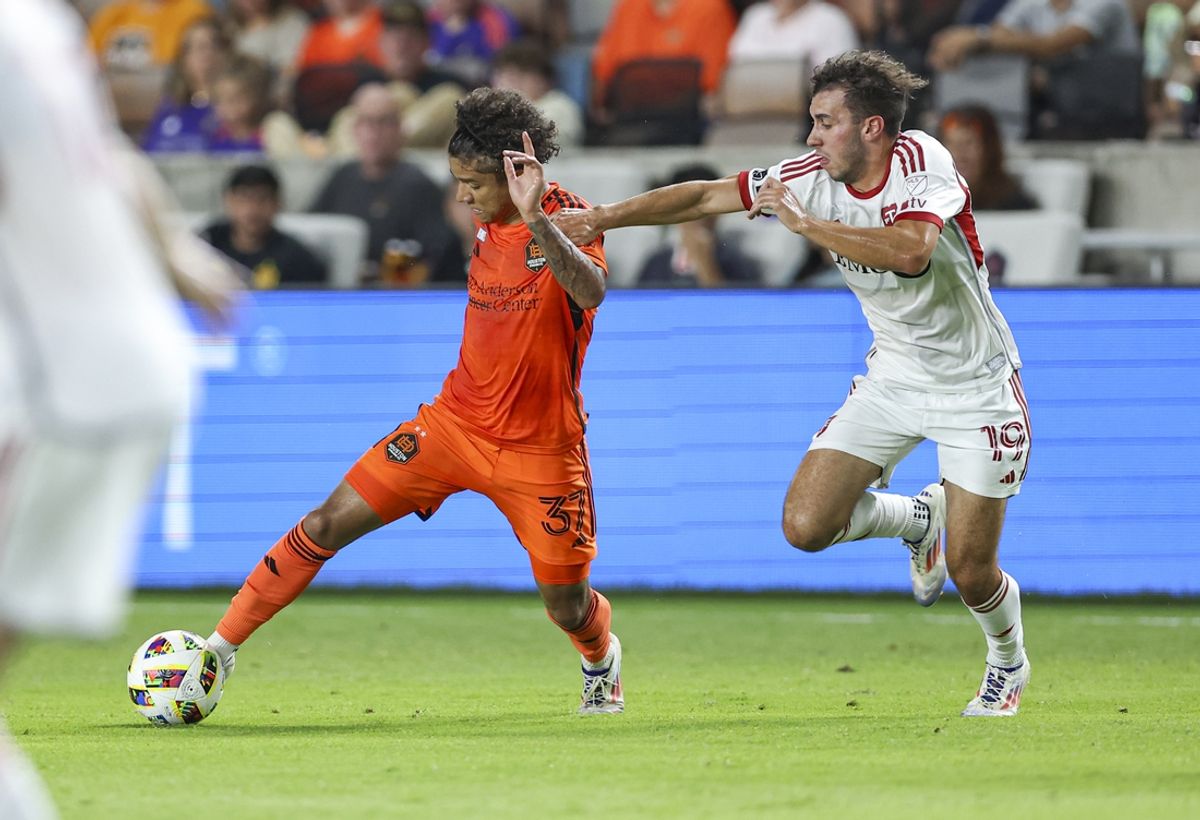 Aug 24, 2024; Houston, Texas, USA; Houston Dynamo FC forward Lawrence Ennali (37) attempts to control the ball as Toronto FC defender Kobe Franklin (19) defends during the second half at Shell Energy Stadium. Mandatory Credit: Troy Taormina-USA TODAY Sports