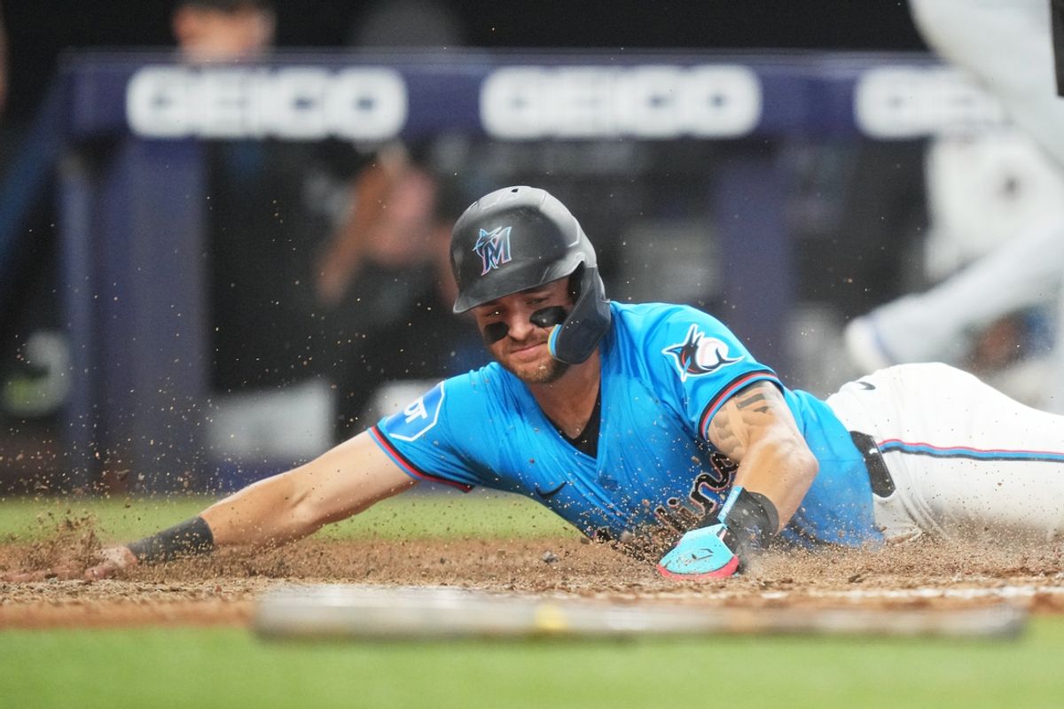 Aug 25, 2024; Miami, Florida, USA;  Miami Marlins designated hitter Connor Norby (24) slides safely into home plate on a sacrifice fly in the eighth inning against the Chicago Cubs at loanDepot Park. Mandatory Credit: Jim Rassol-USA TODAY Sports