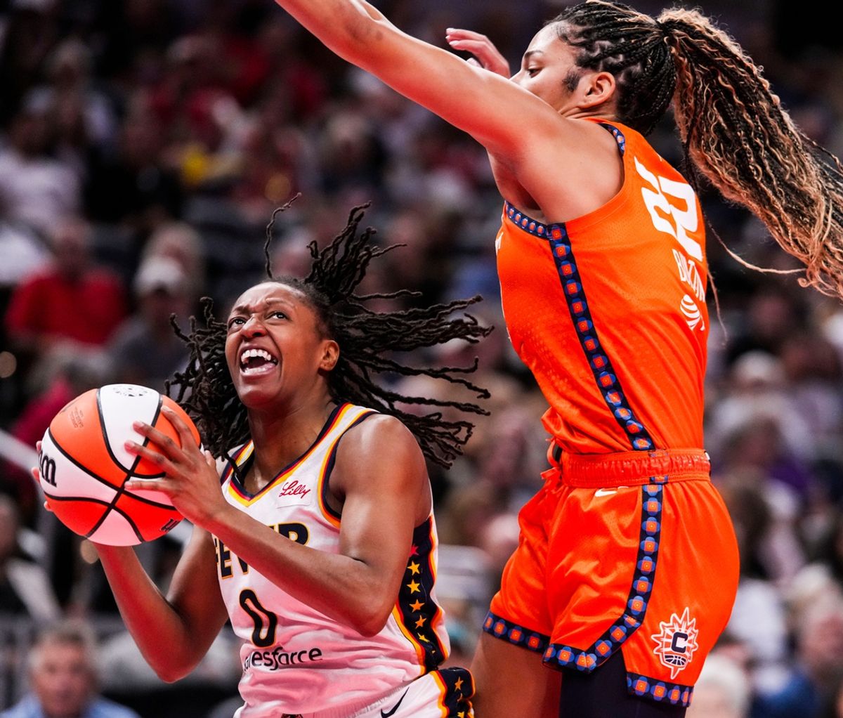 Indiana Fever guard Kelsey Mitchell (0) goes up for a shot against Connecticut Sun guard Veronica Burton (22) on Wednesday, Aug. 28, 2024, during a game between the Indiana Fever and the Connecticut Sun at Gainbridge Fieldhouse in Indianapolis. The Fever defeated the Sun, 84-80.