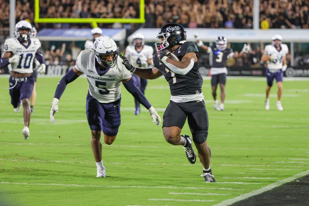 Aug 29, 2024; Orlando, Florida, USA; UCF Knights running back RJ Harvey (7) runs the ball against New Hampshire Wildcats defensive back Wande Owens (5) during the second quarter at FBC Mortgage Stadium. Mandatory Credit: Mike Watters-USA TODAY Sports