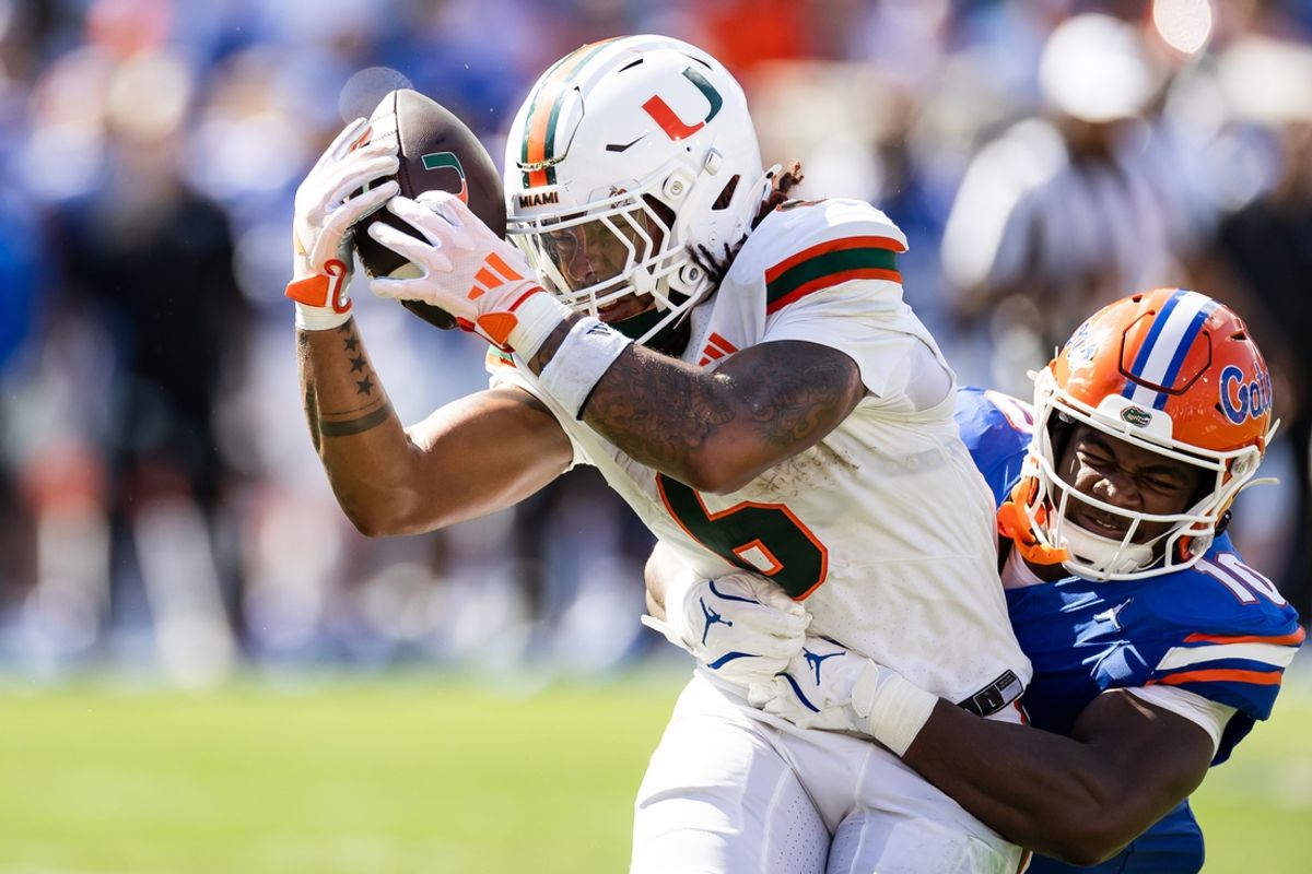 Aug 31, 2024; Gainesville, Florida, USA; Miami Hurricanes running back Damien Martinez (6) makes a catch against Florida Gators linebacker Grayson Howard (10) during the first half at Ben Hill Griffin Stadium. Mandatory Credit: Matt Pendleton-USA TODAY Sports
