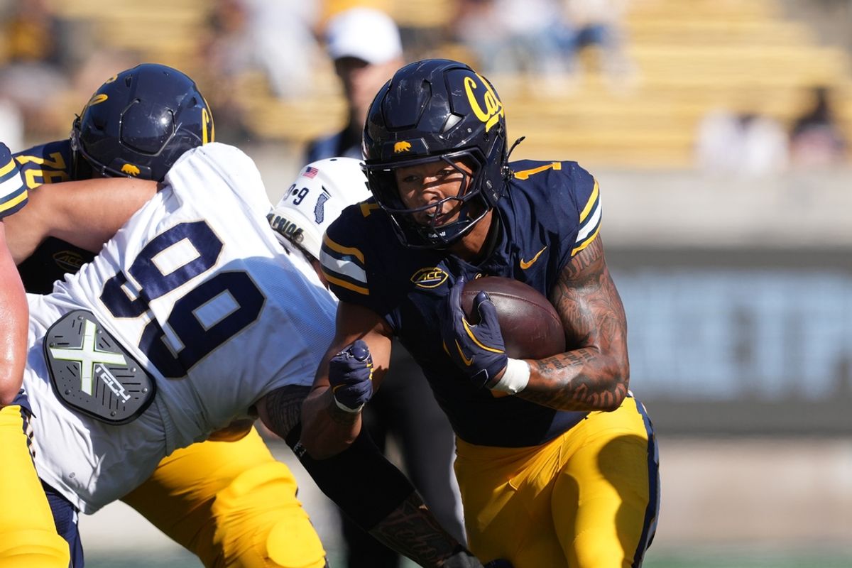 Aug 31, 2024; Berkeley, California, USA; California Golden Bears running back Jaydn Ott (1) carries the ball against UC Davis Aggies defensive lineman Uilisoni Amone (99) during the third quarter at California Memorial Stadium. Mandatory Credit: Darren Yamashita-Imagn Images
