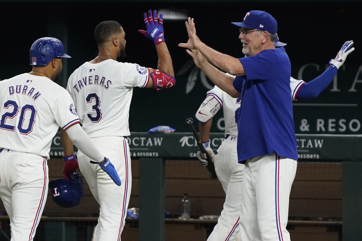 Aug 31, 2024; Arlington, Texas, USA; Texas Rangers center fielder Leody Taveras (3) high fives manager Bruce Bochy (15) as he leaves the field after hitting a walk-off single during the ninth inning against the Oakland Athletics at Globe Life Field. Mandatory Credit: Raymond Carlin III-USA TODAY Sports
