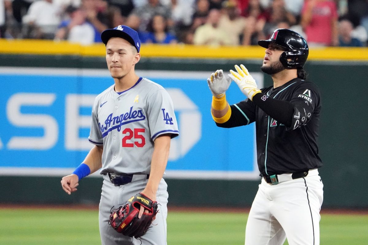 Sep 1, 2024; Phoenix, Arizona, USA; Arizona Diamondbacks third base Eugenio Suárez (28) reacts in front of Los Angeles Dodgers shortstop Tommy Edman (25) after hitting an RBI double  during the second inning at Chase Field. Mandatory Credit: Joe Camporeale-USA TODAY Sports