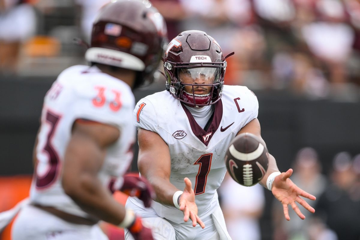 Aug 31, 2024; Nashville, Tennessee, USA;  Virginia Tech Hokies quarterback Kyron Drones (1) pitches the ball to running back Jamoni Jones (33) against the Vanderbilt Commodores during the second half at FirstBank Stadium. Mandatory Credit: Steve Roberts-Imagn Images