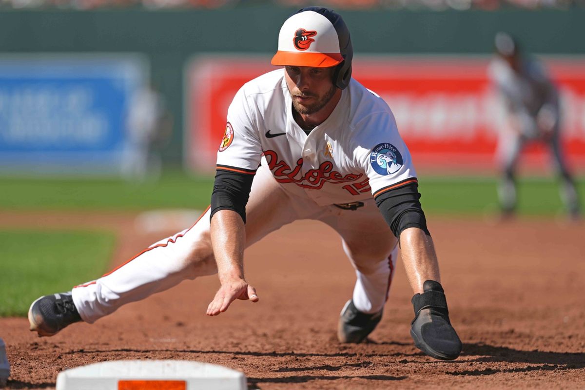 Sep 2, 2024; Baltimore, Maryland, USA; Baltimore Orioles outfielder Austin Slater (15) dives back safely on a second inning pickoff attempt against the Chicago White Sox at Oriole Park at Camden Yards. Mandatory Credit: Mitch Stringer-Imagn Images