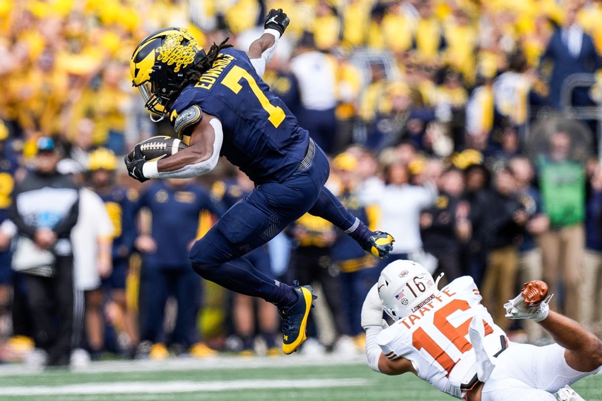 Michigan running back Donovan Edwards (7) runs for a first down against Texas defensive back Michael Taaffe (16) during the first half at Michigan Stadium in Ann Arbor on Saturday, September 7, 2024.