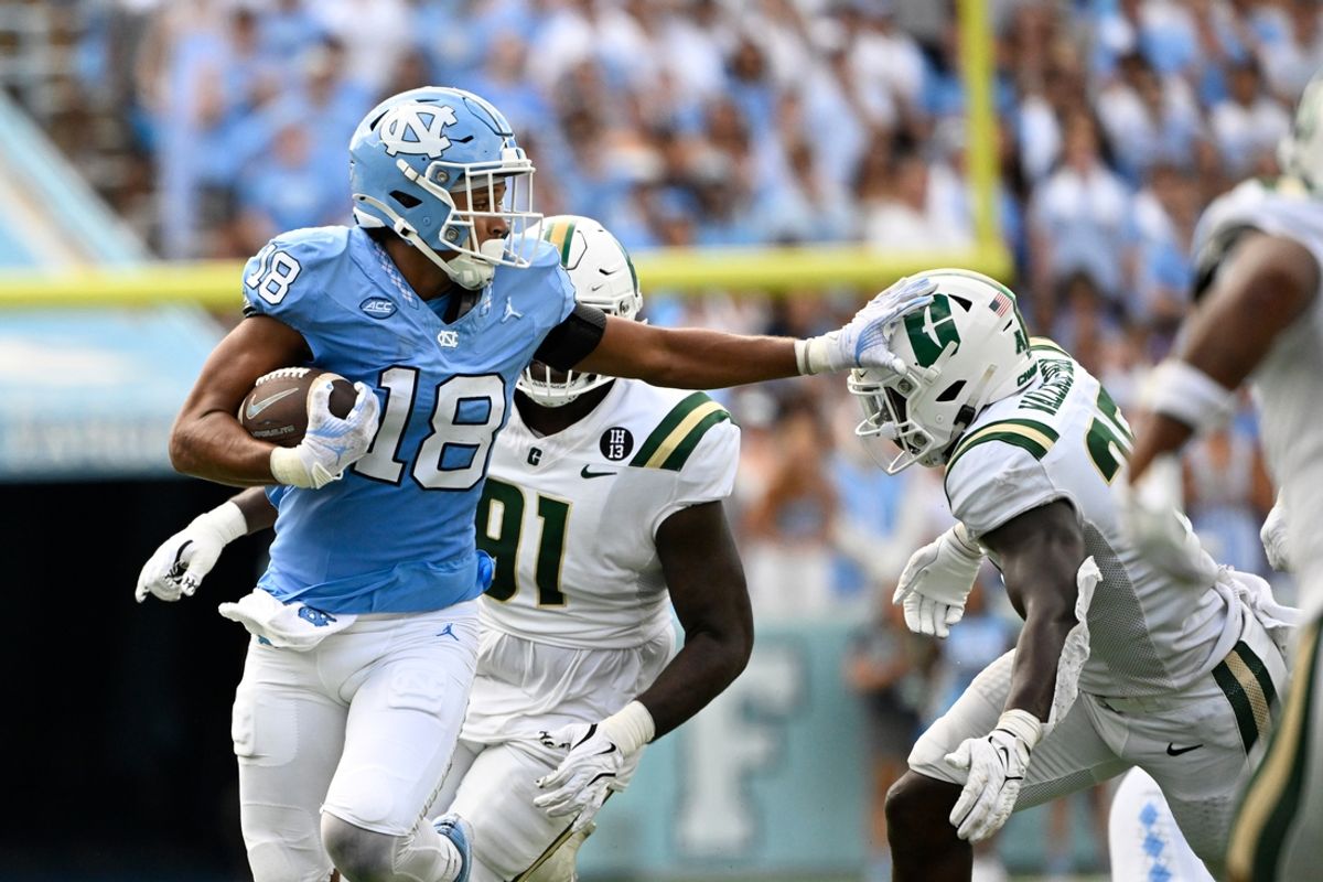 Sep 7, 2024; Chapel Hill, North Carolina, USA; North Carolina Tar Heels tight end Bryson Nesbit (18) with the ball as Charlotte 49ers linebacker Prince Wallace-Bemah (25) defends in the second quarter at Kenan Memorial Stadium. Mandatory Credit: Bob Donnan-Imagn Images