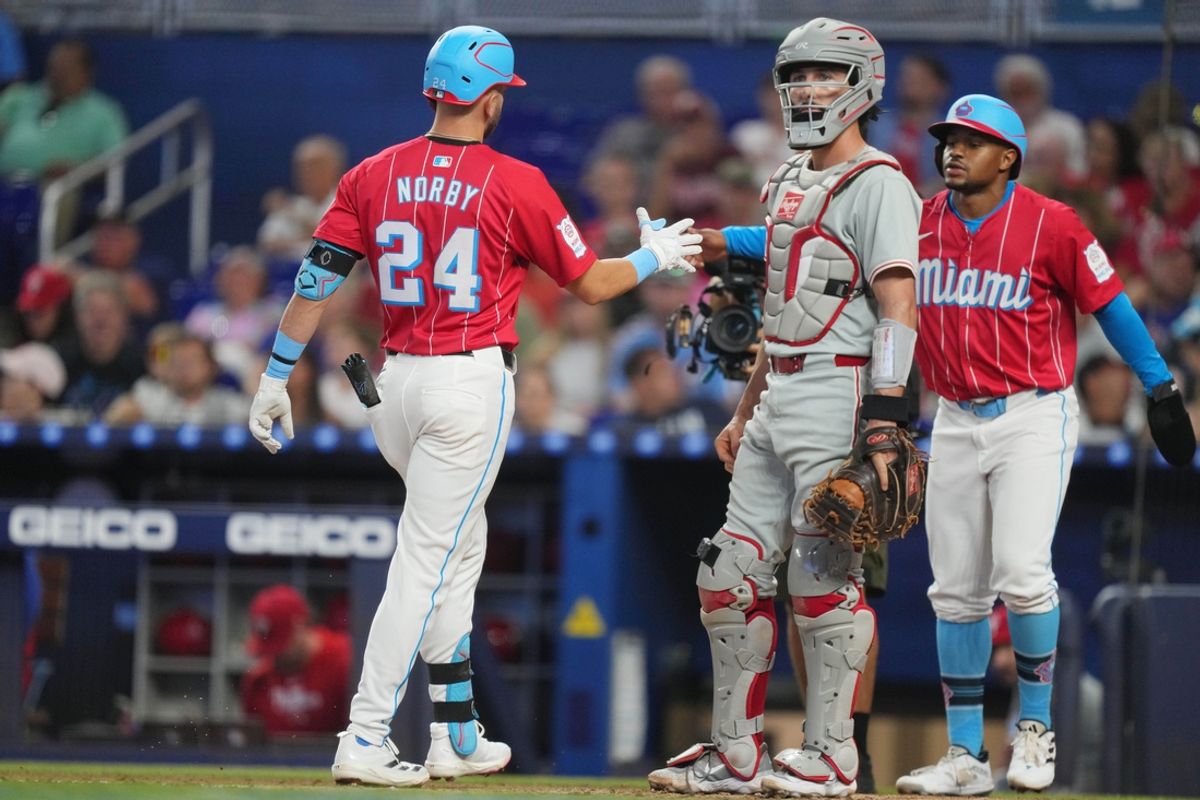 Sep 7, 2024; Miami, Florida, USA;  Miami Marlins third baseman Connor Norby (24) is congratulated by shortstop Xavier Edwards (63) after hitting a two-run home run in the first inning as Philadelphia Phillies catcher Garrett Stubbs (21) looks on at loanDepot Park. Mandatory Credit: Jim Rassol-Imagn Images