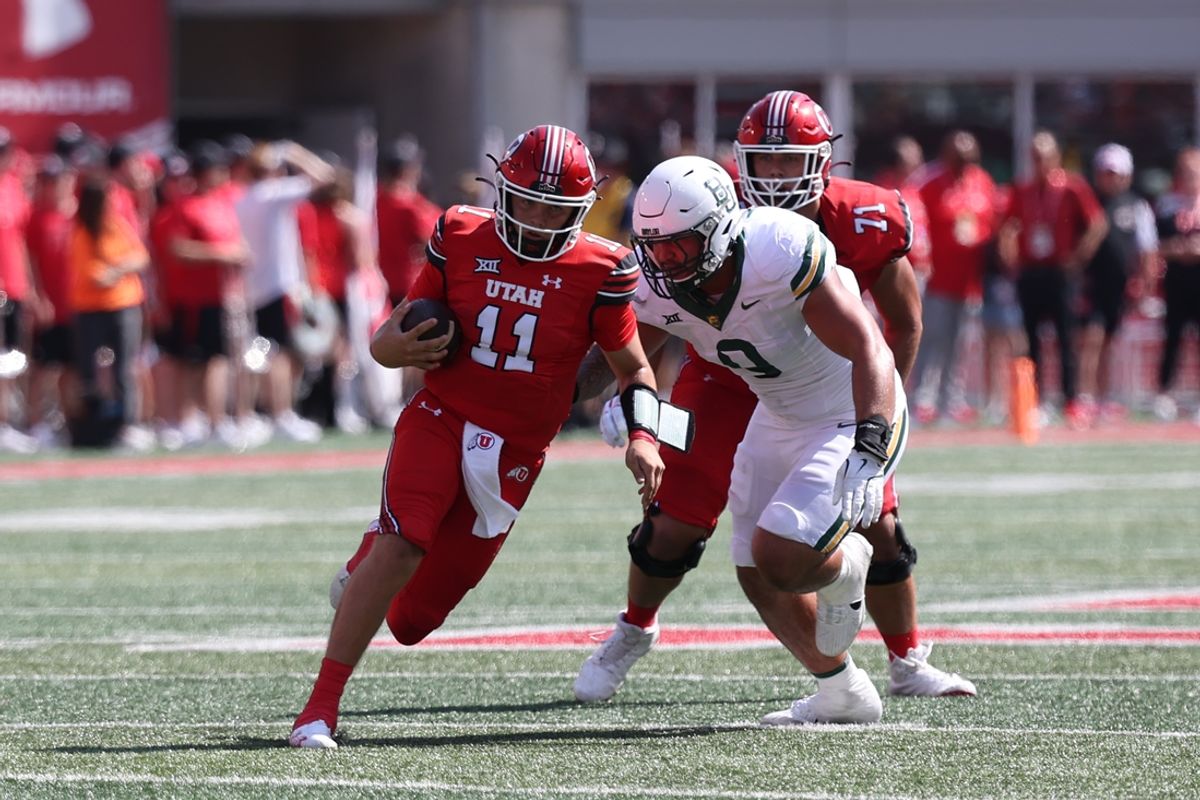Sep 7, 2024; Salt Lake City, Utah, USA; Utah Utes quarterback Isaac Wilson (11) runs the ball against Baylor Bears defensive lineman Jackie Marshall (0) during the second quarter at Rice-Eccles Stadium. Mandatory Credit: Rob Gray-Imagn Images