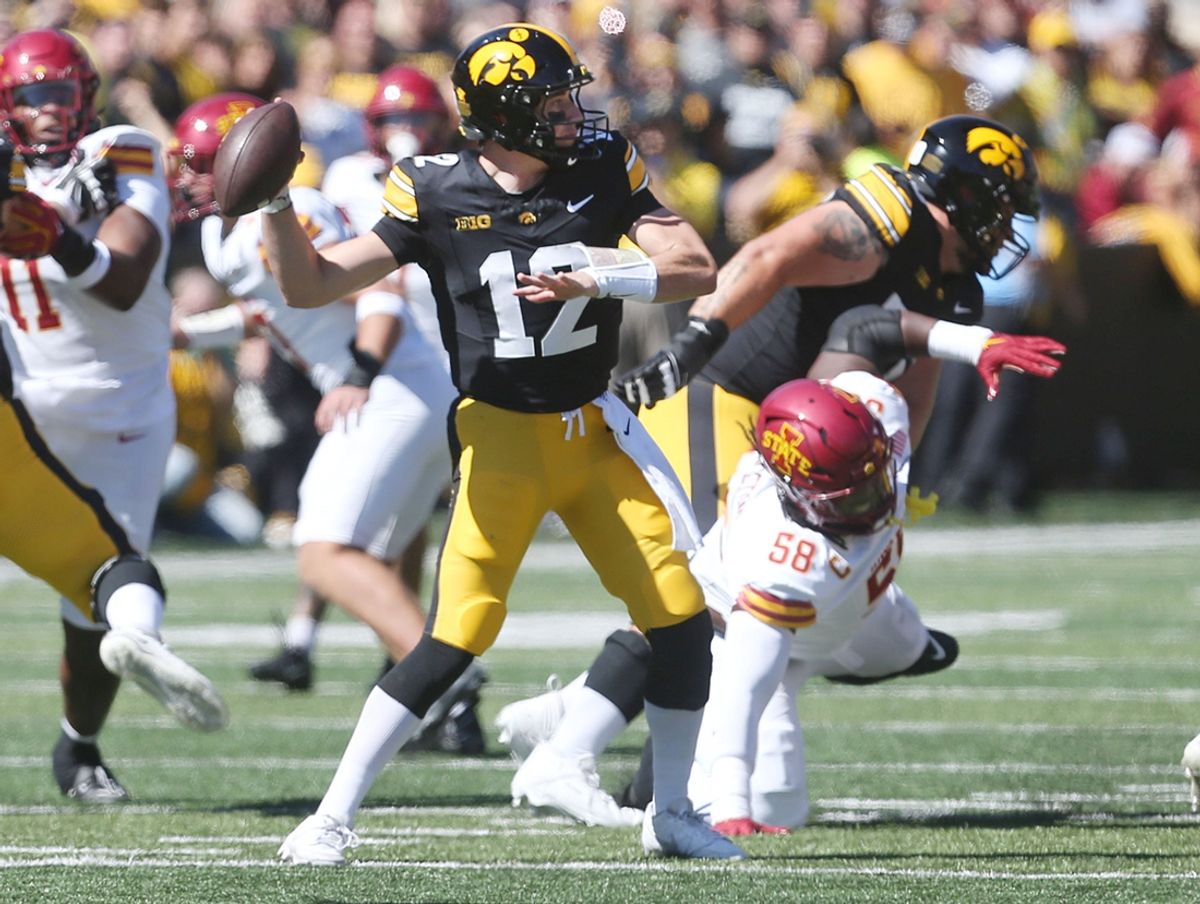 Iowa Hawkeyes's quarter Cade McNamara (12) passes the ball around Iowa State Cyclones defensive line J.R. Singleton (58) during the first quarter in the Cy-Hawk series at Kinnick Stadium on Saturday, Sept. 7, 2024, in Iowa City, Iowa.