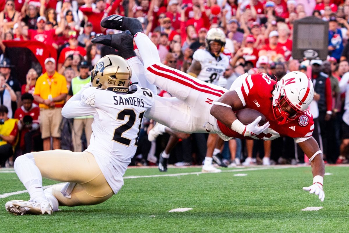 Sep 7, 2024; Lincoln, Nebraska, USA; Nebraska Cornhuskers running back Dante Dowdell (23) dives over Colorado Buffaloes safety Shilo Sanders (21) during the first quarter at Memorial Stadium. Mandatory Credit: Dylan Widger-Imagn Images