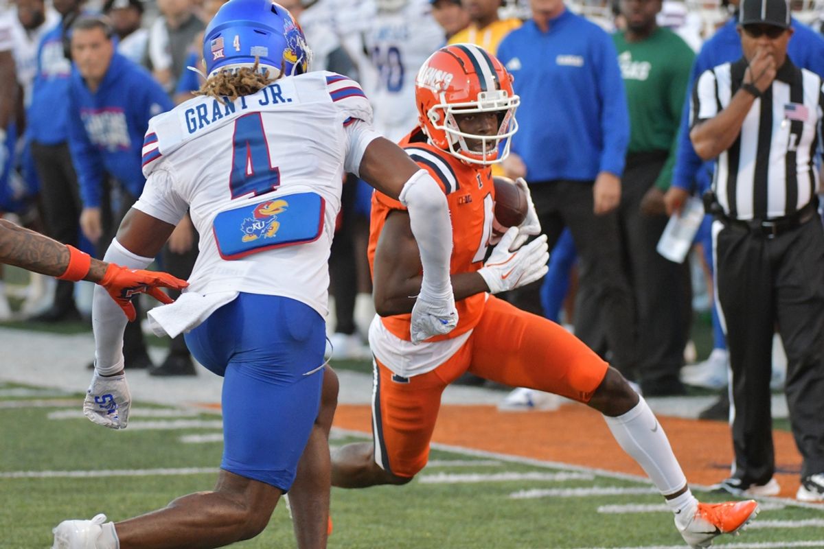 Sep 7, 2024; Champaign, Illinois, USA; Illinois Fighting Illini wide receiver Zakhari Franklin (4) runs for a first down as Kansas Jayhawks safety Marvin Grant (4) pursues during the first half at Memorial Stadium. Mandatory Credit: Ron Johnson-Imagn Images