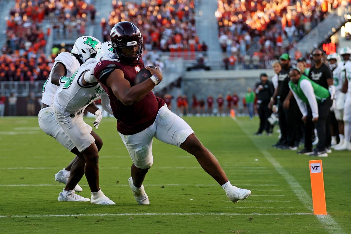 Sep 7, 2024; Blacksburg, Virginia, USA; Virginia Tech Hokies quarterback Kyron Drones (1) run for a touchdown during the third quarter against Marshall Thundering Herd cornerback Jacobie Henderson (10) at Lane Stadium. Mandatory Credit: Peter Casey-Imagn Images