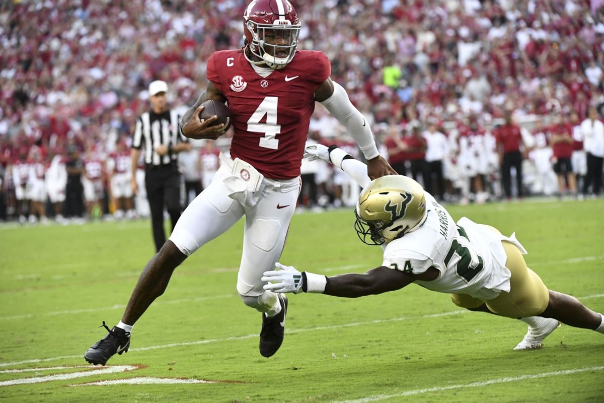 Sep 7, 2024; Tuscaloosa, Alabama, USA;  Alabama Crimson Tide quarterback Jalen Milroe (4) runs for a touchdown against South Florida Bulls defensive lineman Rico Watson III (34) at Bryant-Denny Stadium. Mandatory Credit: Gary Cosby Jr.-Imagn Images
