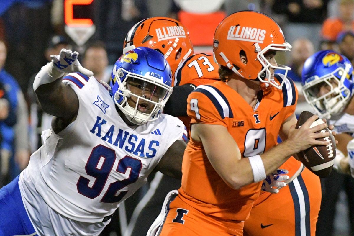 Sep 7, 2024; Champaign, Illinois, USA; Kansas Jayhawks defensive tackle Tommy Dunn Jr. (92) pursues Illinois Fighting Illini quarterback Luke Altmyer (9) during the second half at Memorial Stadium. Mandatory Credit: Ron Johnson-Imagn Images