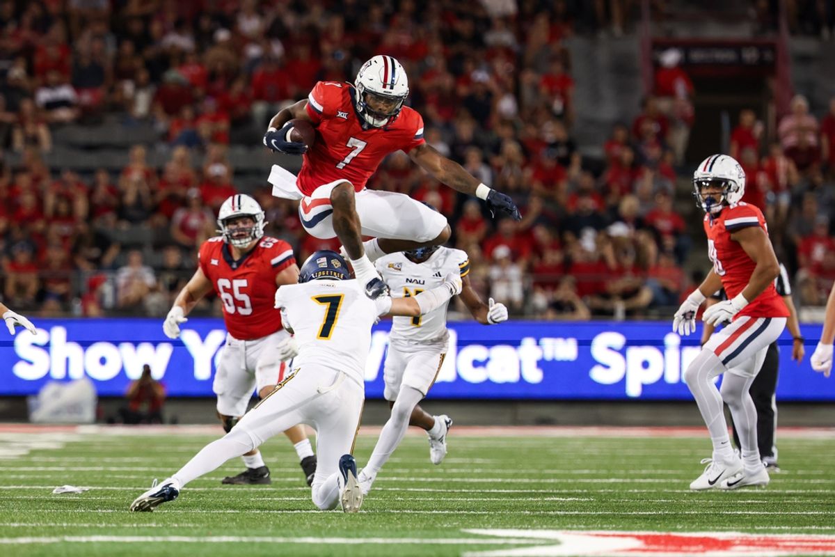 Sep 7, 2024; Tucson, Arizona, USA; Arizona Wildcats running back Quali Conley (7) jumps over Northern Arizona Lumberjacks cornerback Demetrius Freeney (7) during the second quarter at Arizona Stadium. Mandatory Credit: Aryanna Frank-Imagn Images