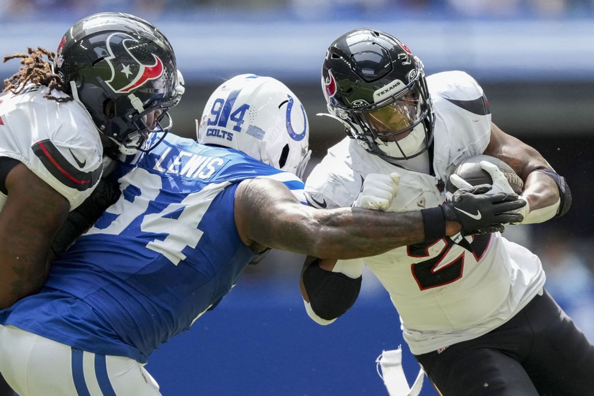 Sep 8, 2024; Indianapolis, Indiana, USA; Indianapolis Colts defensive end Tyquan Lewis (94) looks to bring down Houston Texans running back Joe Mixon (28) at Lucas Oil Stadium. Mandatory Credit: Grace Hollars/USA TODAY Network via Imagn Images