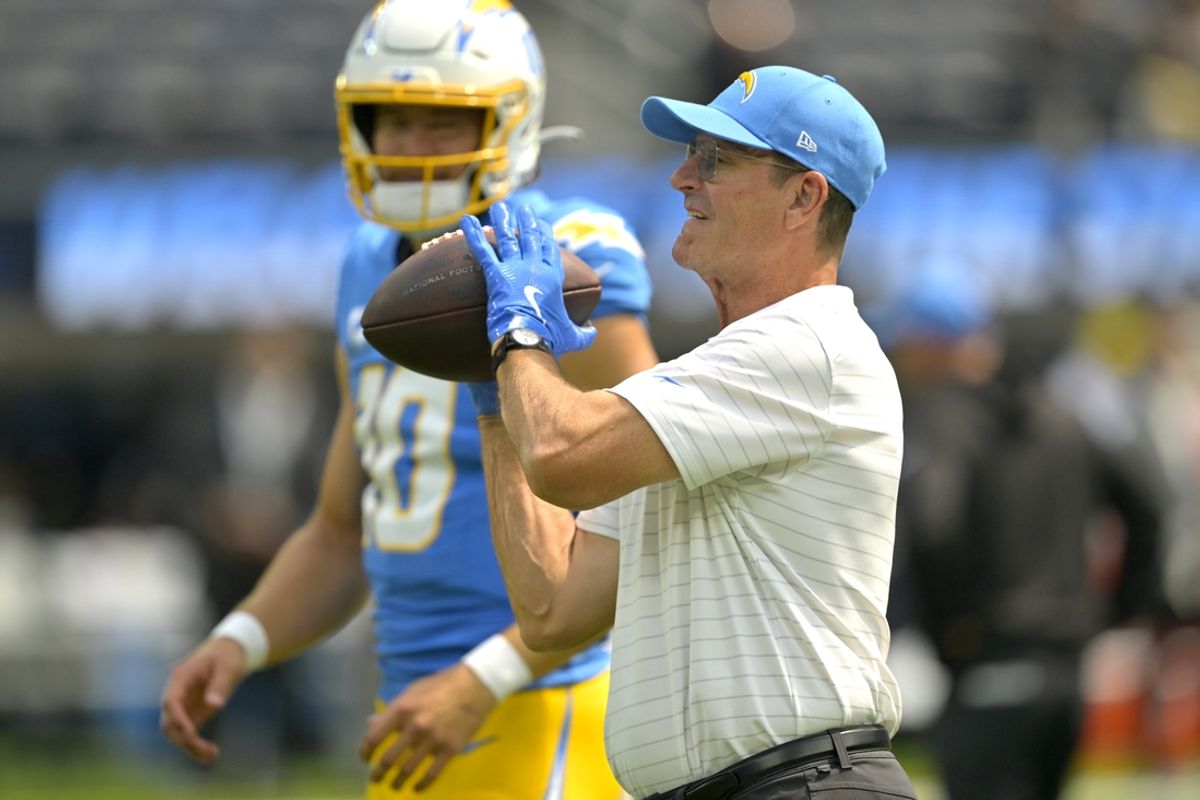 Sep 8, 2024; Inglewood, California, USA; Los Angeles Chargers head coach Jim Harbaugh catches the ball for quarterback Justin Herbert (10) as he warms up prior to the game against the Los Angeles Chargers at SoFi Stadium. Mandatory Credit: Jayne Kamin-Oncea-Imagn Images