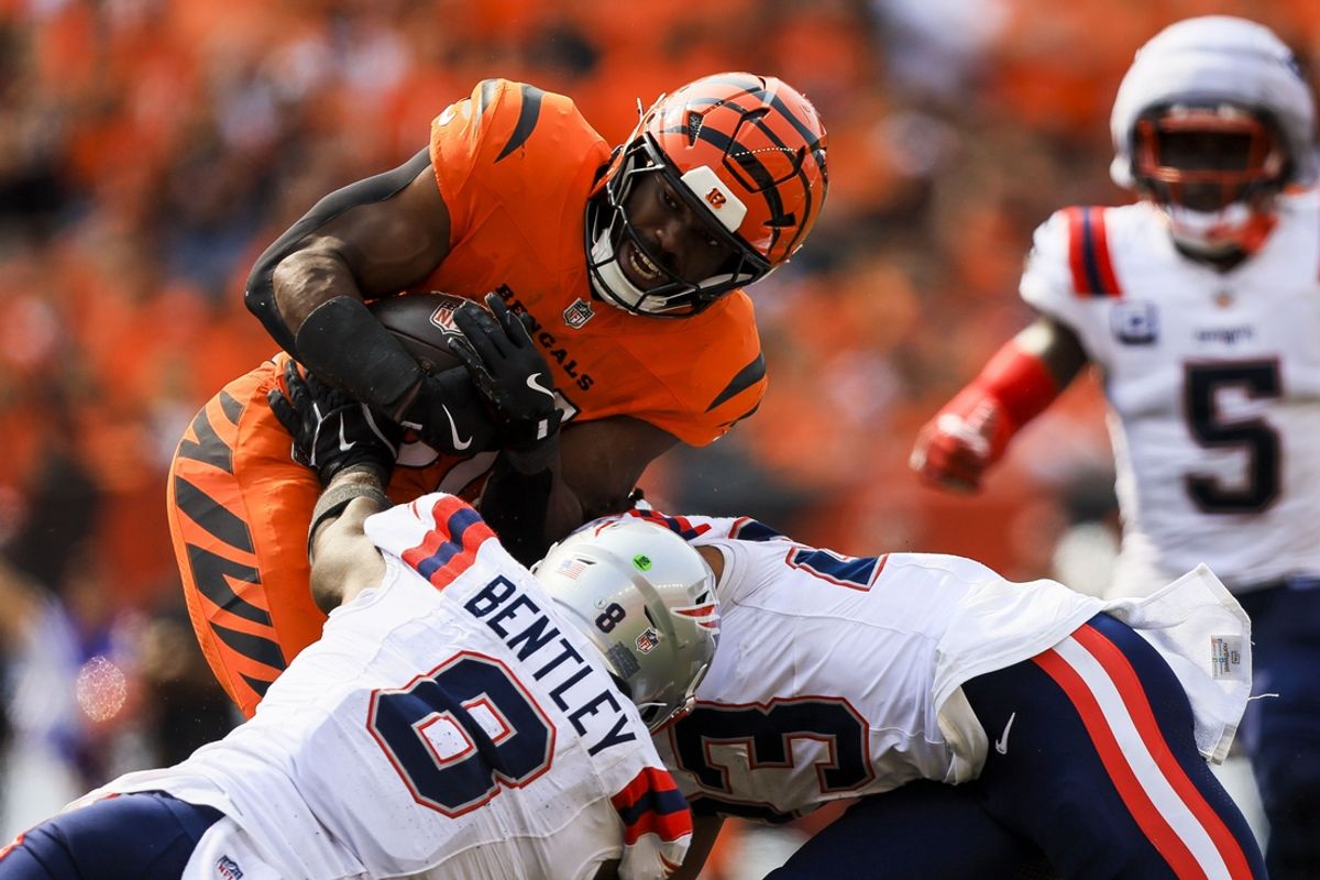 Sep 8, 2024; Cincinnati, Ohio, USA; Cincinnati Bengals running back Zack Moss (31) runs with the ball against New England Patriots linebacker Ja'Whaun Bentley (8) and safety Kyle Dugger (23) in the second half at Paycor Stadium. Mandatory Credit: Katie Stratman-Imagn Images