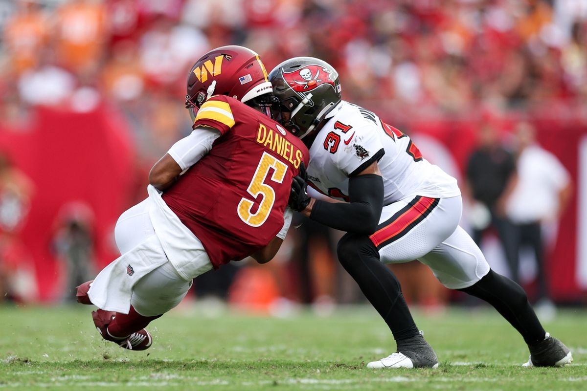 Sep 8, 2024; Tampa, Florida, USA; Washington Commanders quarterback Jayden Daniels (5) is hit by Tampa Bay Buccaneers safety Antoine Winfield Jr. (31) in the second quarter at Raymond James Stadium. Mandatory Credit: Nathan Ray Seebeck-Imagn Images